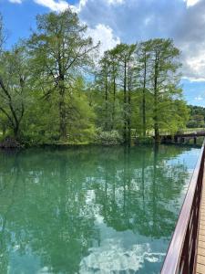 uma vista para um rio com árvores e uma ponte em Appartamento in Franciacorta vicino al Lago Iseo em Corte Franca