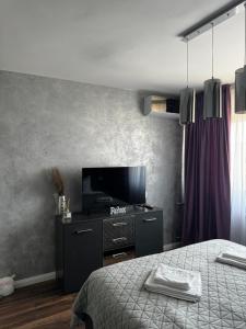Schlafzimmer mit einem Bett und einem Flachbild-TV in der Unterkunft Lovely 2 Rooms apartment in the CENTER of the city in Bukarest