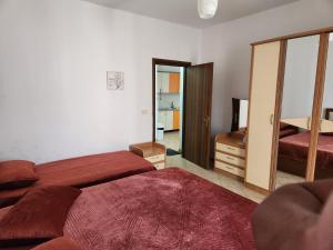 1 dormitorio con 2 camas y espejo en Comfy Beachfront Apartment - 50m from the Sea, en Golem