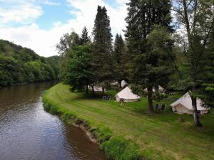 a group of tents next to a river at Lodg'ing Nature Camp Ardennes NEW 2024 in Bouillon