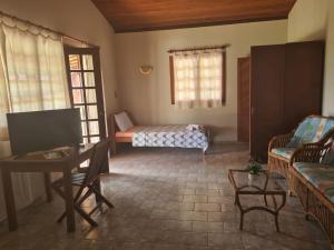 ein Wohnzimmer mit einem Bett, einem Tisch und Stühlen in der Unterkunft HOTEL FAZENDA BOLANDEIRA in Conde