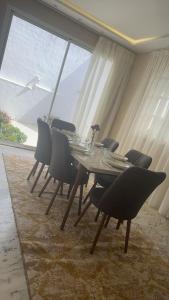 丹吉尔Tanger jbel kber的配有大窗户的客房内的餐桌和椅子