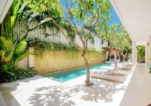 an indoor pool with trees and a fence at Villa Savasana - Rooftop Ocean Sunsets in Canggu