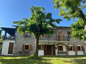 una vieja casa de piedra con un árbol delante en Casa Vigneto - Villa with pool, en Toano