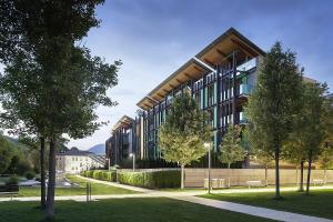 a large building with trees in front of it at GoldenSuitesItaly I Trento Suite 1 & Garage Privato in Trento