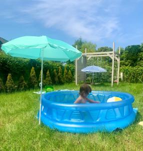 Willa Arkadia Kopalino في كوبالينو: طفل صغير في مسبح ازرق مع مظله