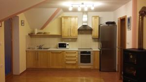 a kitchen with wooden cabinets and a black refrigerator at Tourist Farm Arbajter in Resnik