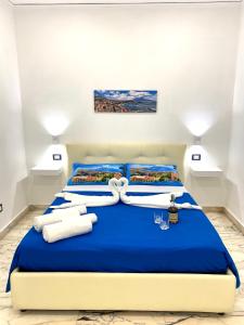 a bedroom with a blue bed with white towels at Castellano apartment in Naples