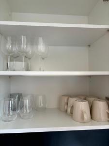 a shelf filled with glasses and wine glasses at Charming Apartement Luxembourg City Center, Parking, Balcony in Luxembourg