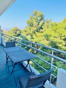 a picnic table and two chairs on a balcony at P C Side NEST in Xylokastro