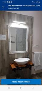 y baño con lavabo blanco y espejo. en IMPERIAL ROOMS - ULTRACENTRAL - jacuzzi cu hidromasaj, en Oradea