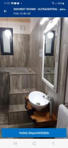 y baño con lavabo y espejo. en IMPERIAL ROOMS - ULTRACENTRAL - jacuzzi cu hidromasaj, en Oradea