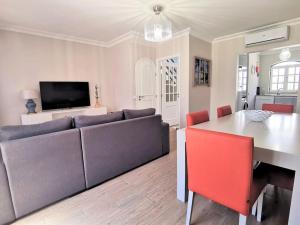 a living room with a couch and a table at Casa Tulipa Ferias - Vilamoura in Quarteira