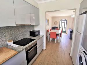 a kitchen with a counter top and a dining room at Casa Tulipa Ferias - Vilamoura in Quarteira