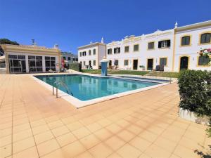 a large swimming pool in front of a building at Casa Tulipa Ferias - Vilamoura in Quarteira