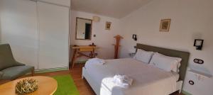 una camera da letto con un letto, una sedia e un tavolo di Casa Da Avo - Turismo De Habitacao a Torre de Moncorvo