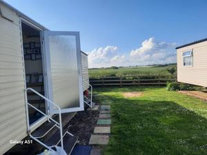 una puerta abierta a una casa con patio en Static Holiday Caravan, en Clacton-on-Sea