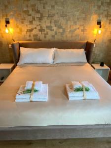 un letto con asciugamani e cuscini sopra di Raisi Suites & Apartment a Catania