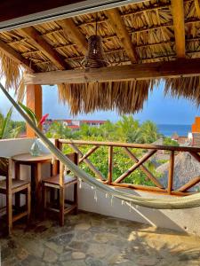 einen Balkon mit einem Tisch und Meerblick in der Unterkunft Hotel Casa Mixteca in Zipolite
