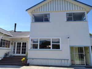 ein weißes Haus mit großen Fenstern in der Unterkunft My Place in Hokitika