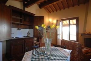 un vaso con fiori gialli su un tavolo in cucina di Poggio Mille a Castiglione del Lago