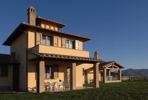 een huis met een tafel en stoelen ervoor bij Poggio Mille in Castiglione del Lago