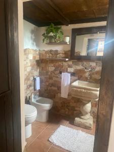 La salle de bains en pierre est pourvue d'un lavabo et de toilettes. dans l'établissement Casetta Vacanze Nonna Antonietta, à Carbonia