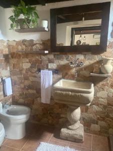 La salle de bains est pourvue d'un lavabo, de toilettes et d'un miroir. dans l'établissement Casetta Vacanze Nonna Antonietta, à Carbonia