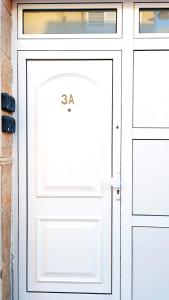 Una puerta de garaje blanca con el número. en Seagull Estudios, en Pozo Izquierdo
