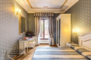 
a bedroom with a bed and a dresser at Hotel La Lumiere Di Piazza Di Spagna in Rome
