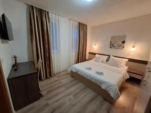 a hotel room with a bed and a desk and window at Villa Gaga in Međugorje +30 photos