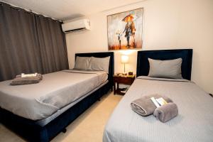 1 dormitorio con 2 camas y mesa con lámpara en Charming Retreat with Patio Access and FREE Laundry, en Ponce