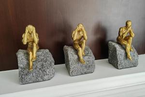 three gold statues sitting on rocks on a shelf at Estia Project, Leisure - Billiards - Jacuzzi in Gournes
