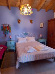 sypialnia z łóżkiem i żyrandolem w obiekcie Charme Rústico w Aljezur