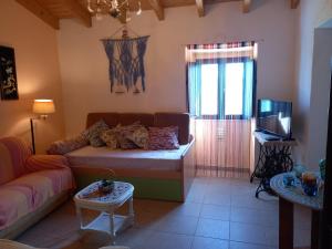 a living room with a couch and a tv at Charme Rústico in Aljezur