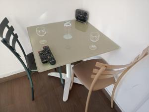 a table with wine glasses and a remote control on it at Victoria in La Marsa