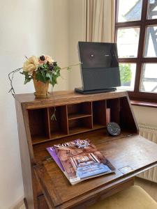 a wooden table with a television and a vase of flowers at Haus Dürresbach in Hennef