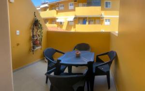 a table and chairs on a balcony with a building at Apartamento Francês in Marechal Deodoro