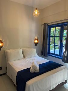 a bedroom with a bed with two towels on it at Pousada Maikai Garden in Porto Belo