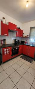 a red kitchen with red cabinets and a stove at Maison Calme aux Avirons in Les Avirons