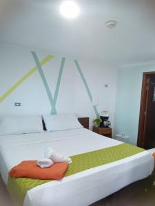 a bedroom with a large bed with two towels on it at Hotel Najjez in Villavicencio +15 photos