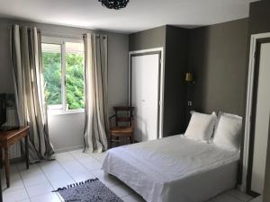 a bedroom with a white bed and a window at Thebertisa in Valréas