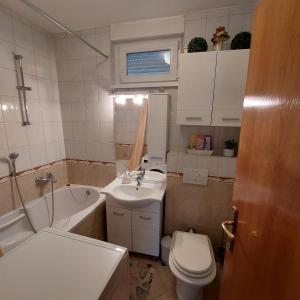 a bathroom with a toilet and a sink and a tub at Apartment Meli Varazdin in Varaždin