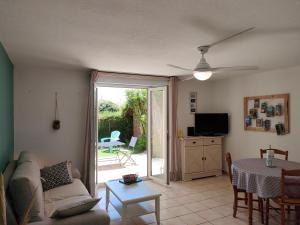 uma sala de estar com um sofá e uma mesa em appartement en rez-de-chaussée et terrasse sans vis a vis em Canet-en-Roussillon