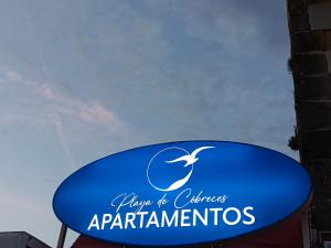 una señal azul para la entrada de los apartamentos en Estudios Playa De Cóbreces, en Cóbreces