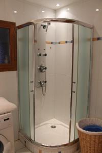 La salle de bains est pourvue d'une douche avec une porte en verre. dans l'établissement Maison Familiale À Recey-Sur Ource, à Recey-sur-Ource