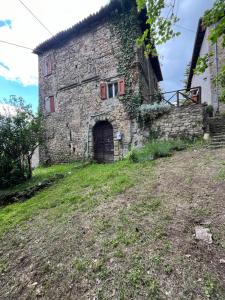 an old stone building with a door on a hill at Borgo Il Monzone in Castel dʼAiano