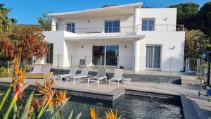a villa with a swimming pool in front of a house at Villa Vellutini in Calvi