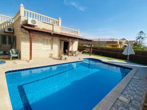 a swimming pool in front of a house at قريه شاطئ الشروق in Dawwār Ḩalīs