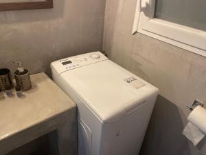 a white washer and dryer in a small bathroom at Lazy Lizard in Nea Karvali